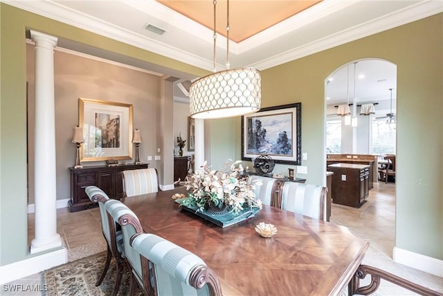 dining area with ornate columns, ornamental molding, light tile patterned floors, and a tray ceiling