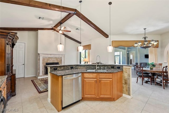 kitchen featuring pendant lighting, sink, dishwasher, an island with sink, and dark stone counters