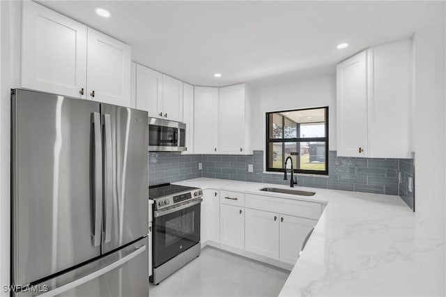 kitchen with sink, white cabinets, and appliances with stainless steel finishes