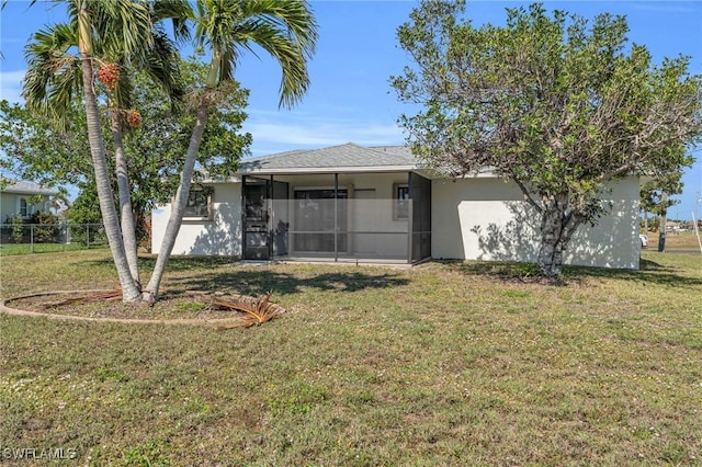 rear view of property with a yard and a sunroom