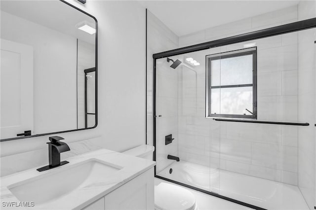 full bathroom with toilet, vanity, and shower / bath combination with glass door