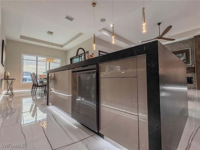 kitchen featuring pendant lighting and a raised ceiling