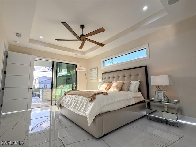 bedroom featuring a tray ceiling, access to outside, and ceiling fan