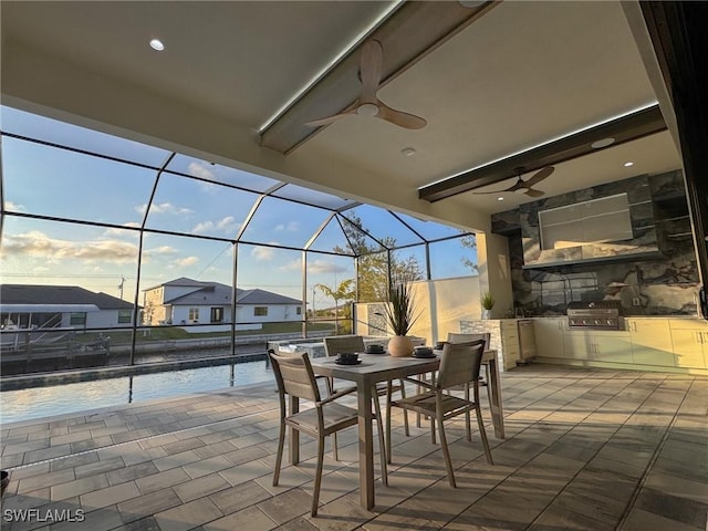 view of patio featuring ceiling fan, area for grilling, grilling area, and glass enclosure