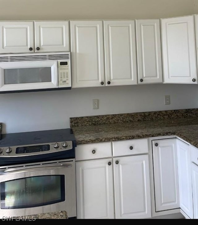 kitchen featuring electric stove and white cabinets