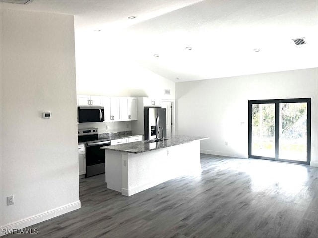 kitchen featuring sink, a kitchen island with sink, stainless steel appliances, white cabinets, and dark stone counters