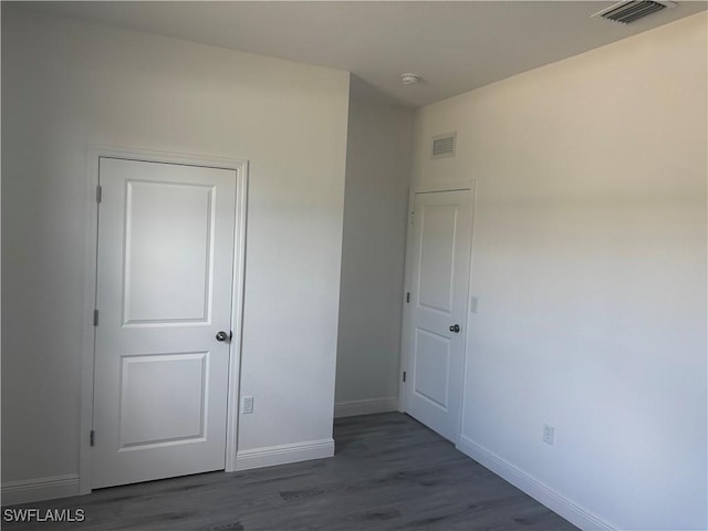 unfurnished bedroom with dark wood-type flooring