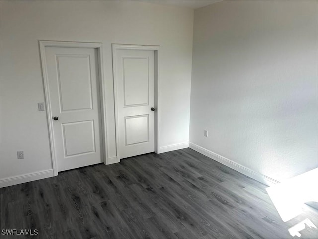 unfurnished bedroom with dark wood-type flooring