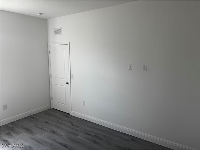 unfurnished room featuring dark wood-type flooring