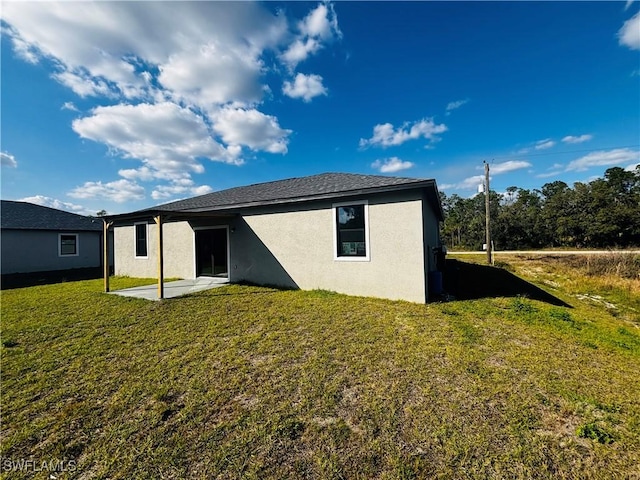 rear view of property with a patio and a lawn