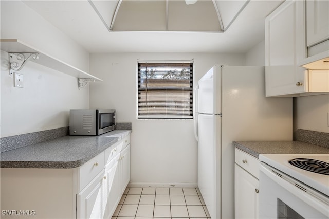 kitchen featuring electric stove, light tile patterned floors, and white cabinets