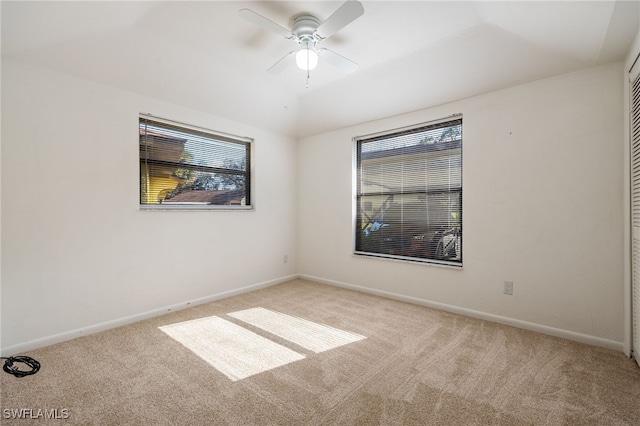 carpeted empty room with plenty of natural light and ceiling fan