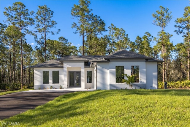 rear view of house featuring french doors and a lawn