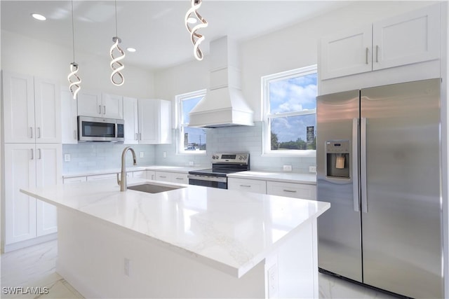 kitchen featuring appliances with stainless steel finishes, sink, white cabinetry, custom range hood, and hanging light fixtures