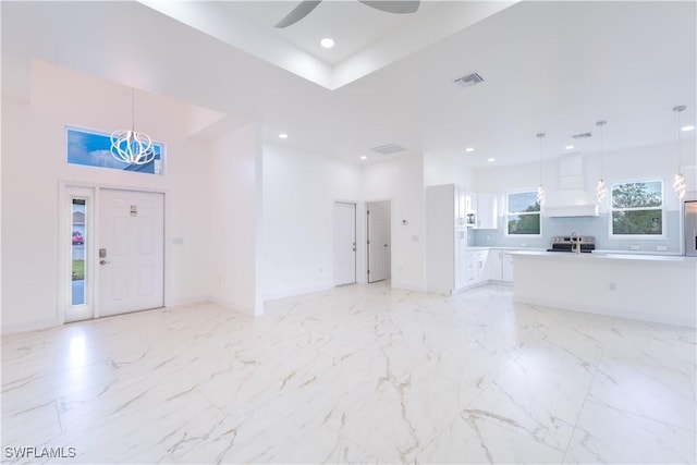 interior space with ceiling fan and a towering ceiling