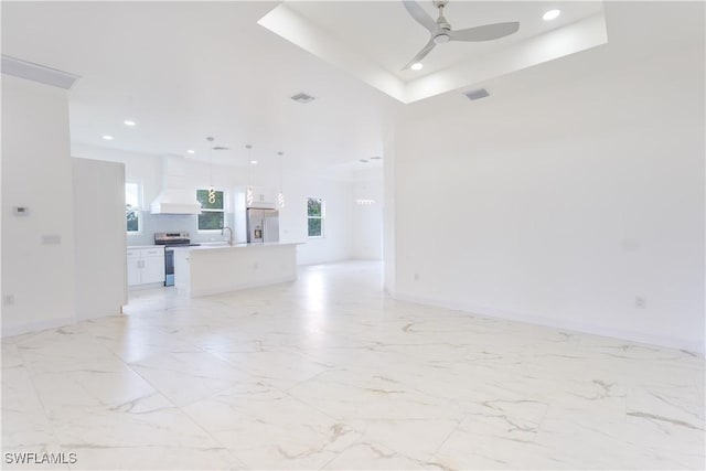 unfurnished living room with ceiling fan