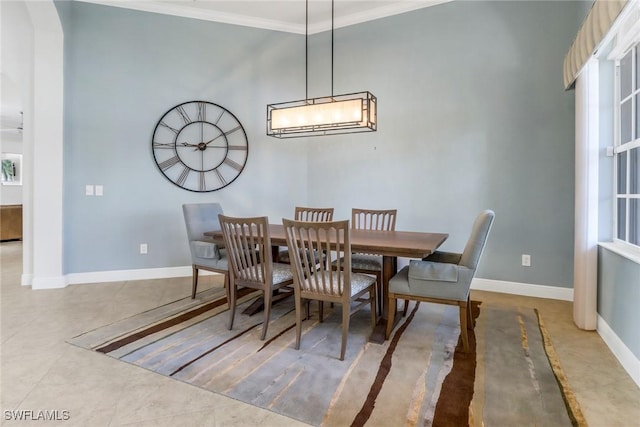 dining area with crown molding and tile patterned flooring