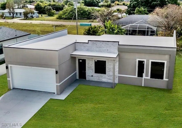 view of front of property featuring a garage, a front yard, and glass enclosure