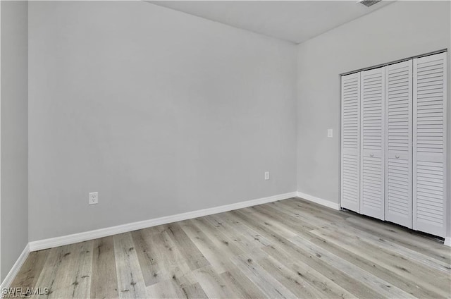 unfurnished bedroom featuring a closet and light wood-type flooring