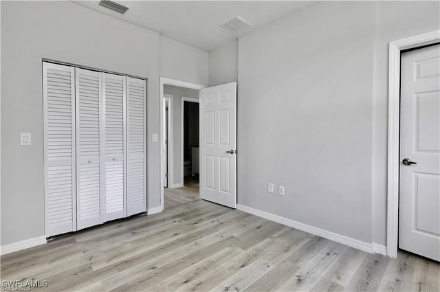 unfurnished bedroom with light wood-type flooring and a closet