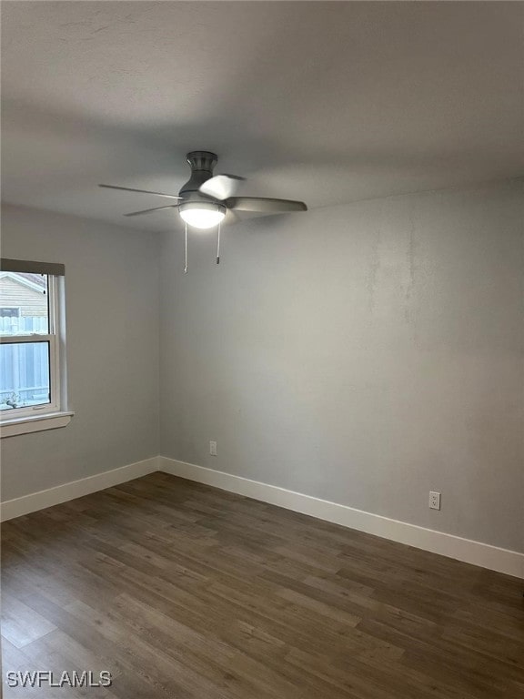 unfurnished room featuring dark wood-type flooring and ceiling fan