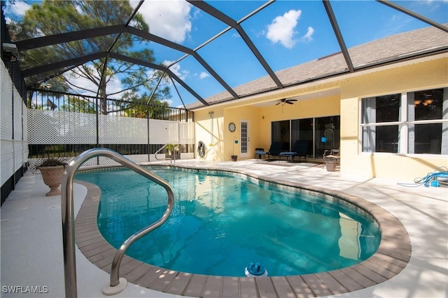 view of pool with ceiling fan, glass enclosure, and a patio area