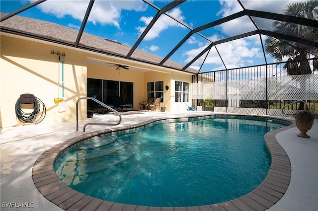 view of pool with a patio area, ceiling fan, and glass enclosure