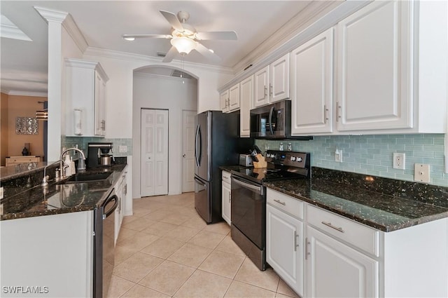 kitchen with stainless steel appliances, white cabinetry, sink, and dark stone counters