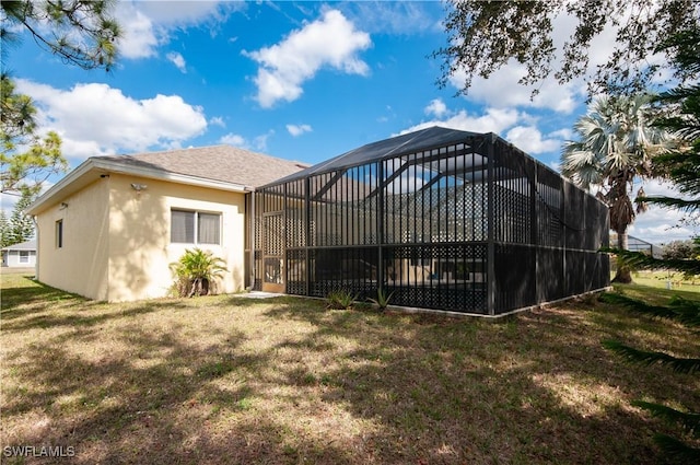 back of property with a lanai and a lawn