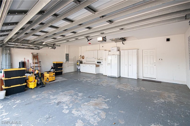 garage with a garage door opener, white refrigerator with ice dispenser, electric water heater, and electric panel