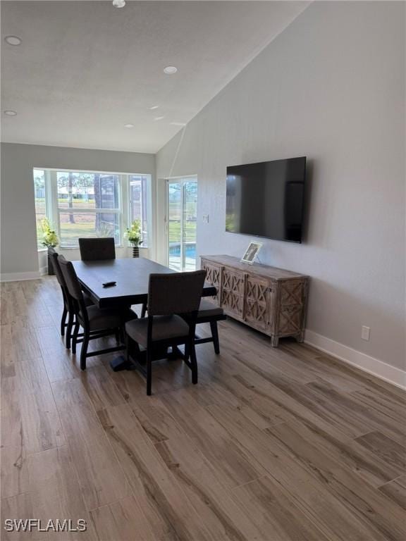 dining area with lofted ceiling and wood-type flooring