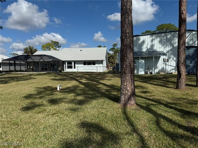 back of house with glass enclosure and a lawn