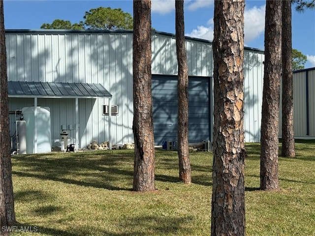 view of side of property featuring an outbuilding and a lawn