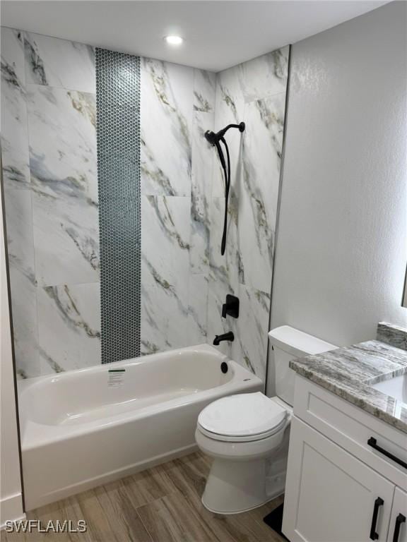 full bathroom with vanity, tiled shower / bath combo, wood-type flooring, and toilet