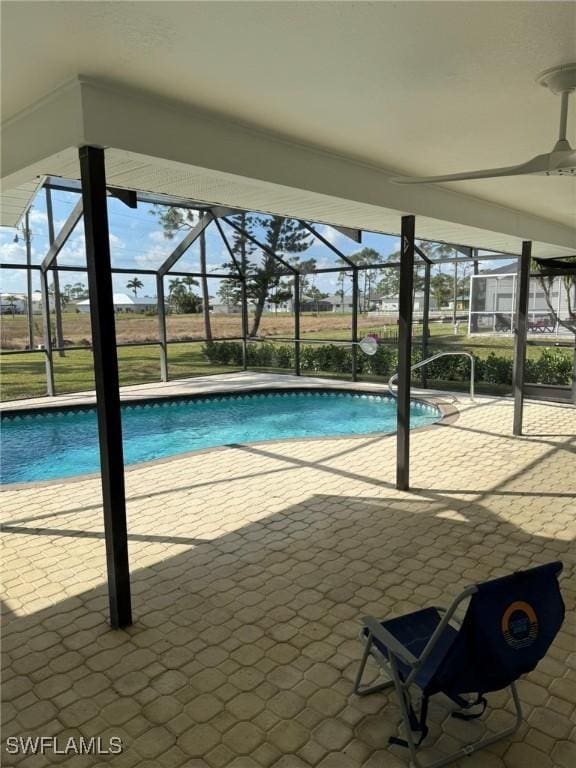 view of pool with ceiling fan, a patio area, and glass enclosure