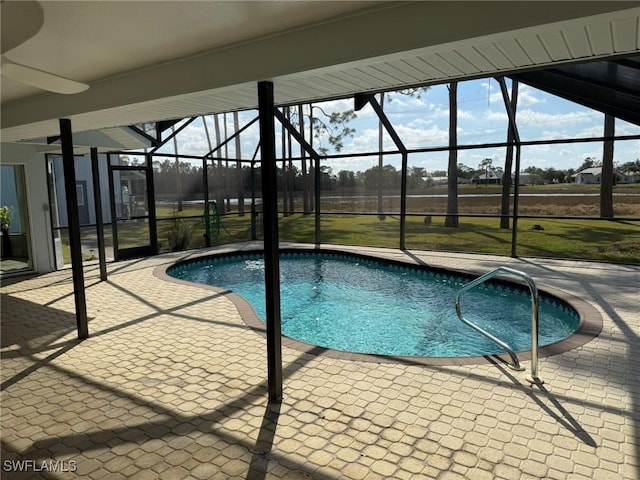 view of pool with glass enclosure and a patio area