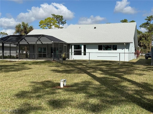 rear view of property featuring glass enclosure, fence, stucco siding, and a yard