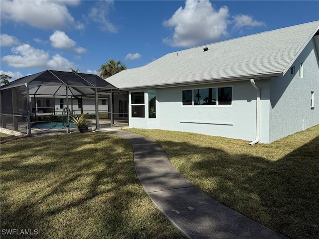 rear view of house with a yard, a lanai, an outdoor pool, and stucco siding