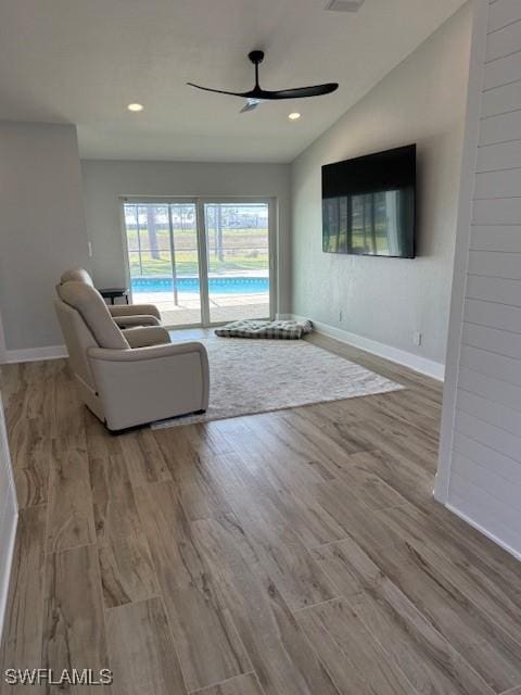 unfurnished living room with ceiling fan, vaulted ceiling, wood finished floors, and recessed lighting