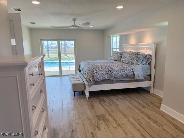 bedroom featuring access to exterior, multiple windows, visible vents, and light wood finished floors