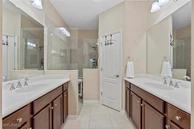 bathroom with tile patterned flooring, vanity, and tiled shower