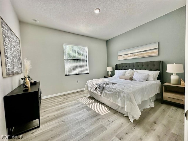 bedroom featuring a textured ceiling and light wood-type flooring