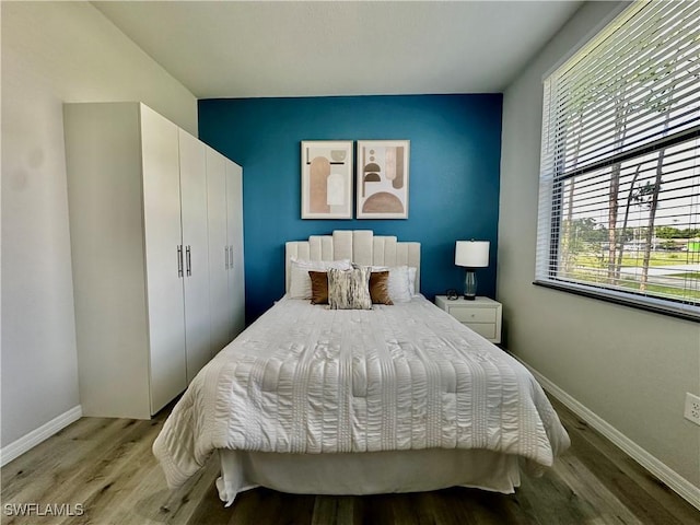 bedroom with light hardwood / wood-style flooring and a closet