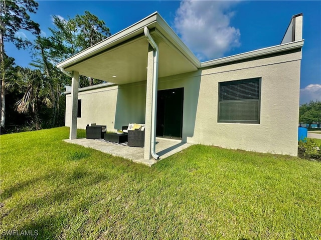 back of house featuring an outdoor hangout area, a patio area, and a lawn