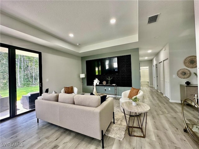 living room featuring a textured ceiling and light wood-type flooring