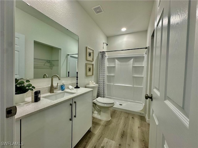 bathroom featuring vanity, a shower with curtain, wood-type flooring, and toilet