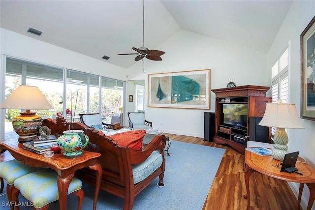 living room with ceiling fan, high vaulted ceiling, a healthy amount of sunlight, and dark hardwood / wood-style floors