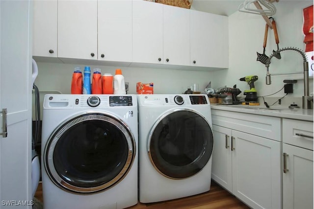 clothes washing area with cabinets, dark wood-type flooring, sink, and independent washer and dryer