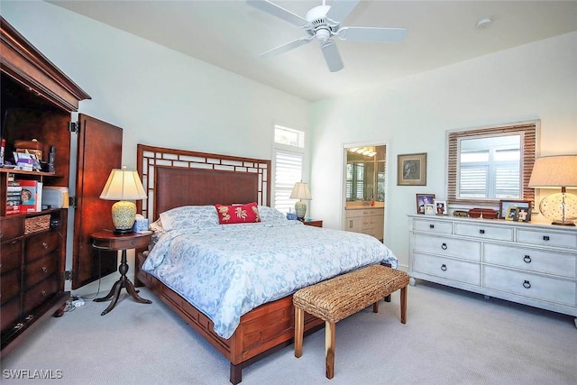 bedroom featuring light carpet, ceiling fan, and ensuite bathroom