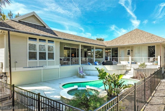 back of house with a swimming pool with hot tub and a patio area